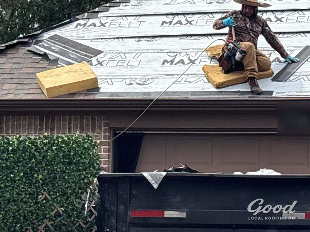 Roofer working across a dried-in roof deck during shingle installation.
